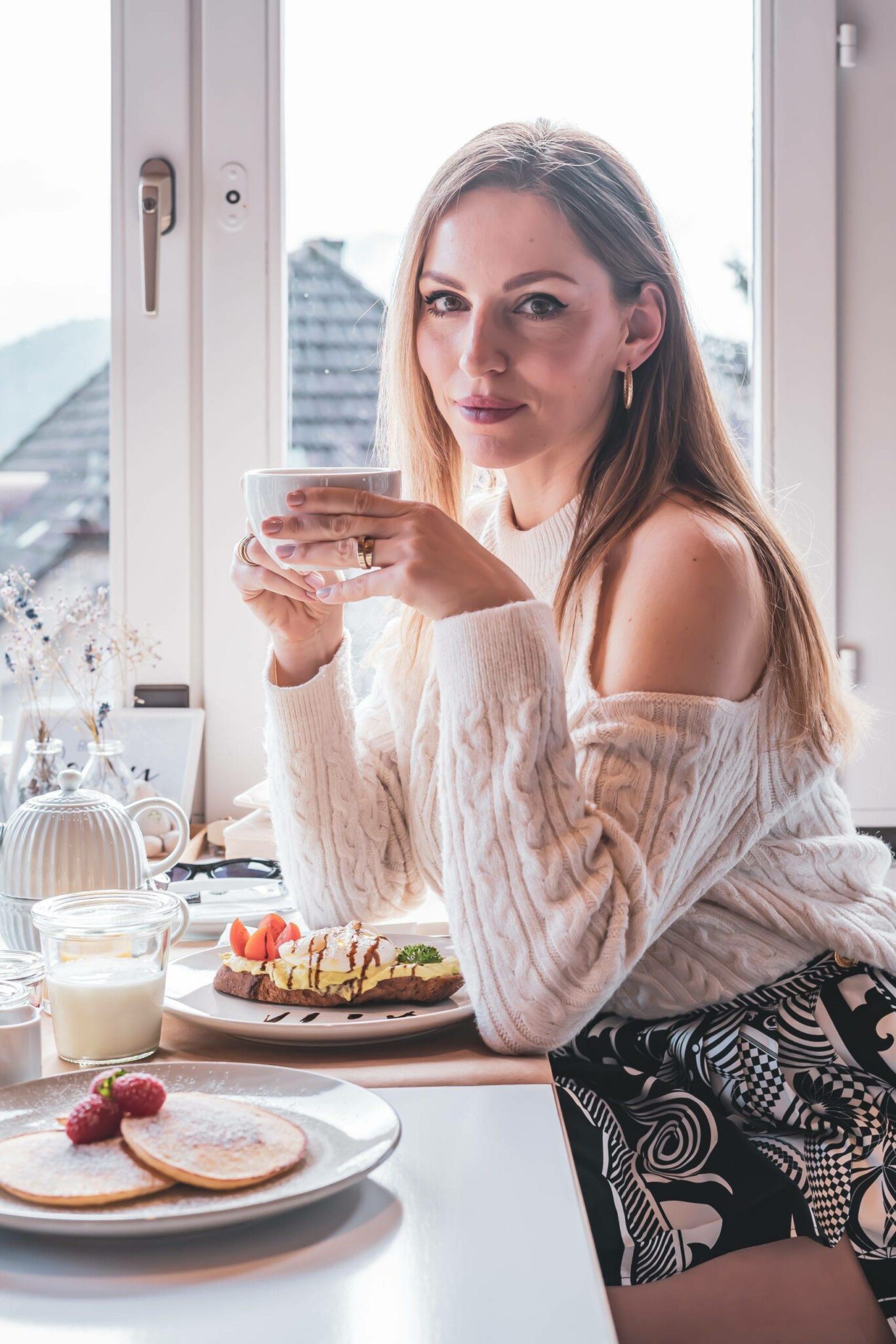 Girl drinking coffee in La Belle Vue Spiez boutique hotel 