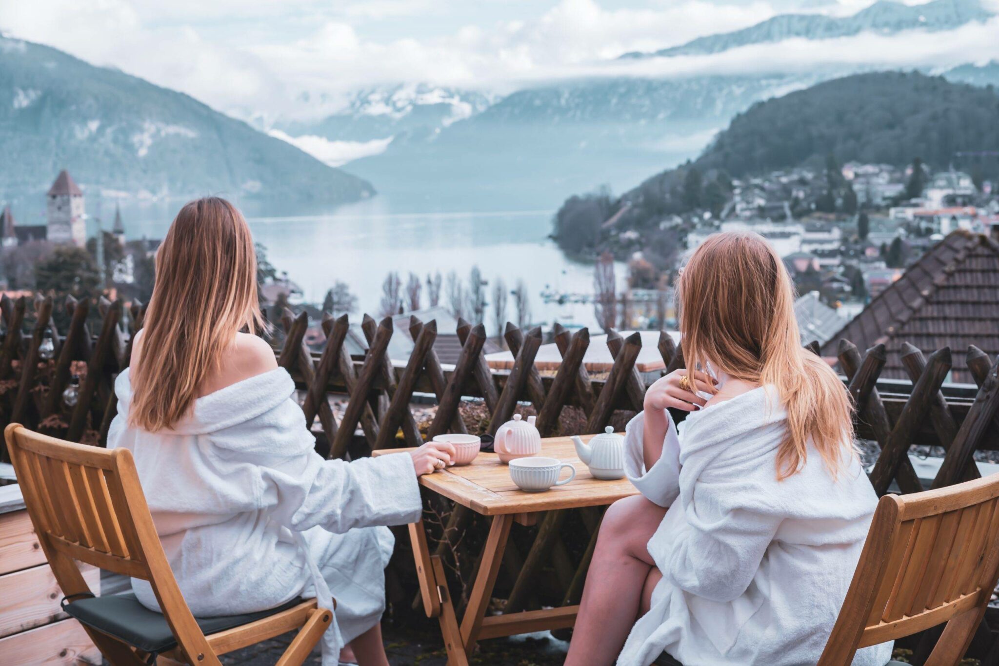 2 girls drinking coffee on a balcony in La Belle Vue Spiez hotel. View on lake Thun. Bellazofia and Anna Swissmermaid 